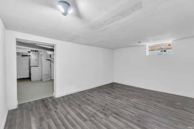 below grade area featuring baseboards, wood finished floors, and a textured ceiling