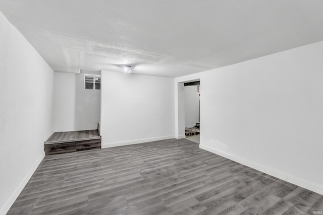finished below grade area featuring baseboards and wood finished floors