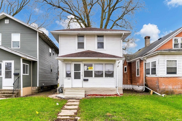view of front of property with entry steps and a front lawn