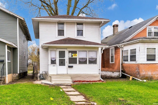 back of property featuring entry steps, a yard, and roof with shingles