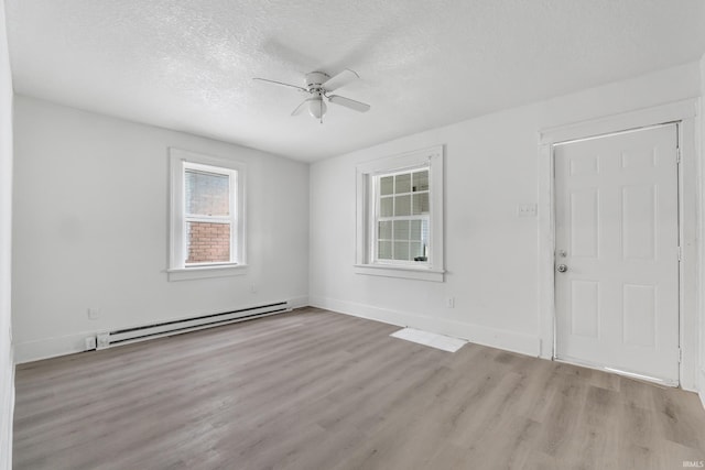 unfurnished room featuring baseboards, a baseboard radiator, ceiling fan, a textured ceiling, and wood finished floors