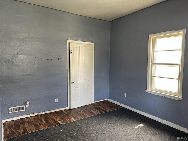carpeted empty room with visible vents and baseboards