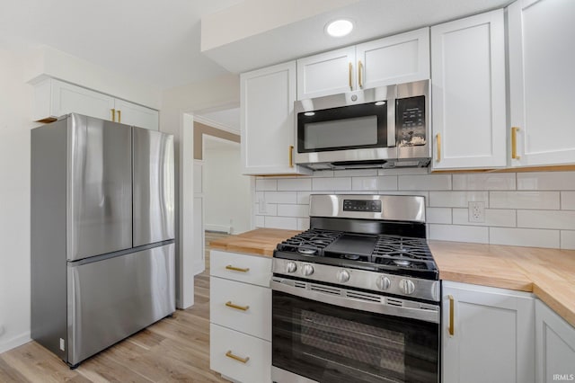 kitchen with butcher block counters, appliances with stainless steel finishes, backsplash, and white cabinets