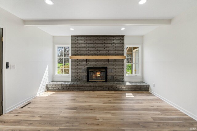 unfurnished living room with baseboards, a brick fireplace, beam ceiling, recessed lighting, and wood finished floors