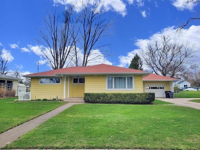 ranch-style home featuring a garage, fence, a front yard, and concrete driveway