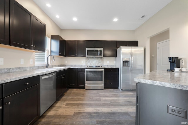 kitchen with light countertops, visible vents, stainless steel appliances, light wood finished floors, and a sink