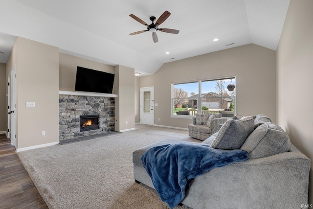living area featuring a fireplace, ceiling fan, vaulted ceiling, and baseboards
