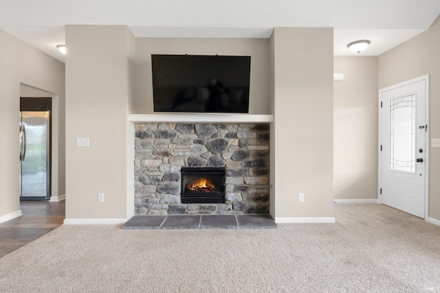 unfurnished living room with carpet floors, baseboards, and a fireplace