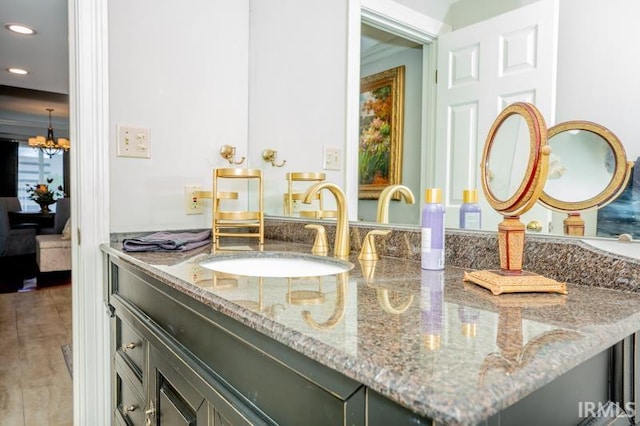 bathroom featuring recessed lighting, an inviting chandelier, and vanity