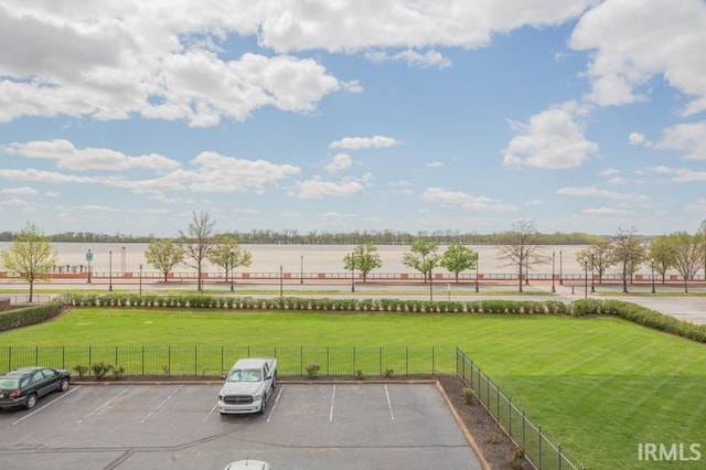 view of yard featuring fence and a water view