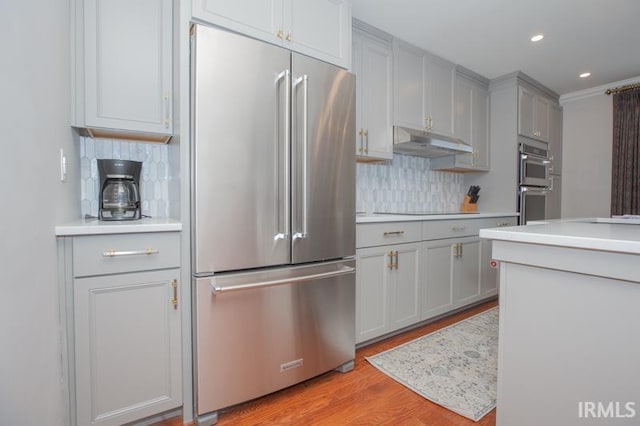 kitchen featuring backsplash, appliances with stainless steel finishes, gray cabinetry, and under cabinet range hood