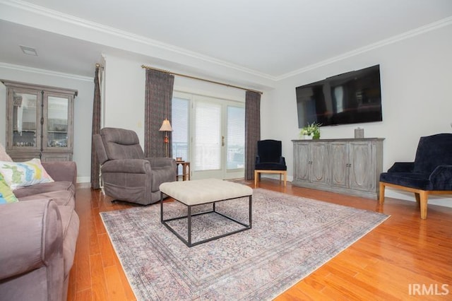 living area featuring crown molding, baseboards, visible vents, and light wood-style floors