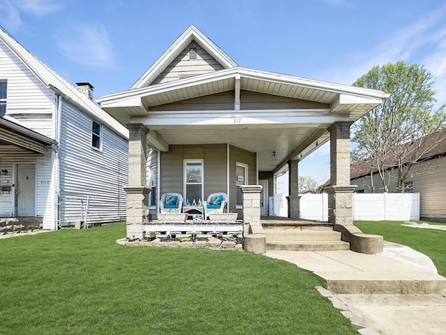 shotgun-style home with covered porch, a front yard, and fence