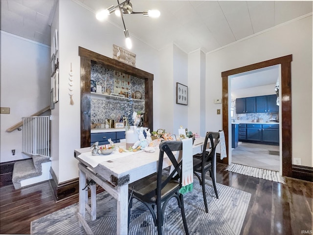 dining space with dark wood-style flooring, ornamental molding, and baseboards