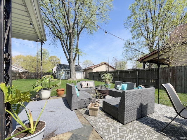 view of patio / terrace featuring an outdoor structure, an outdoor living space with a fire pit, and a fenced backyard