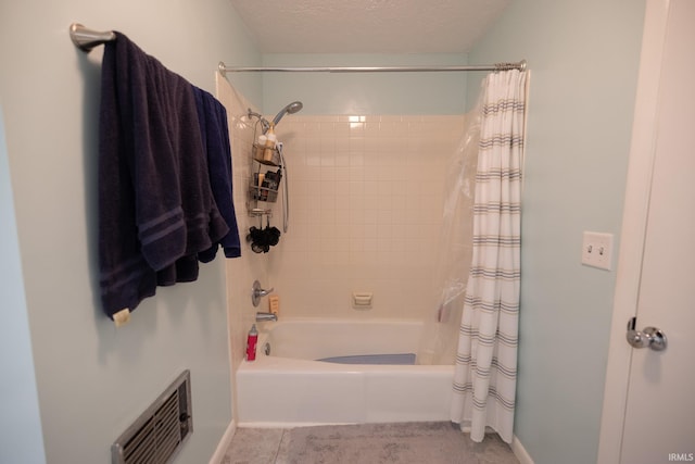 bathroom featuring shower / bathtub combination with curtain, a textured ceiling, and baseboards