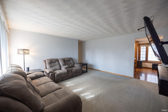 carpeted living room with baseboards and a textured ceiling