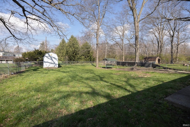 view of yard with a fenced backyard, an outdoor structure, and a storage unit