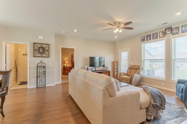 living area with recessed lighting, a ceiling fan, and wood finished floors