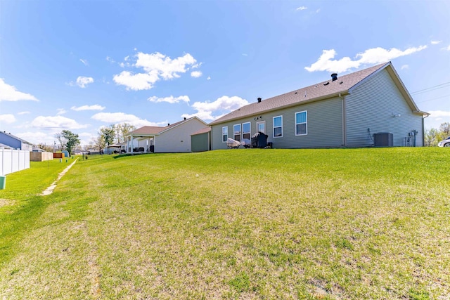 view of yard featuring fence and central AC
