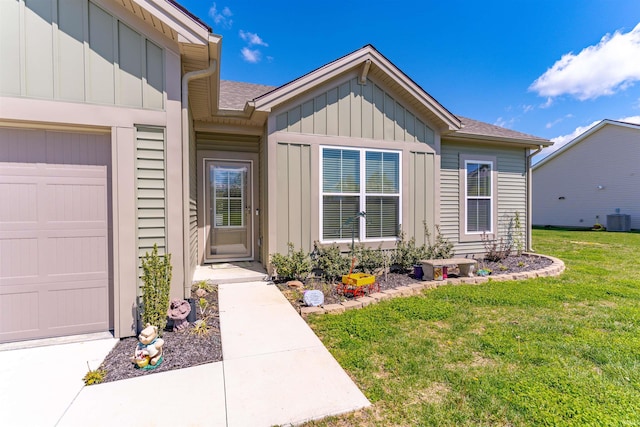 property entrance featuring central air condition unit, board and batten siding, an attached garage, and a lawn
