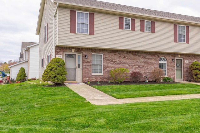 view of property with a front yard and brick siding