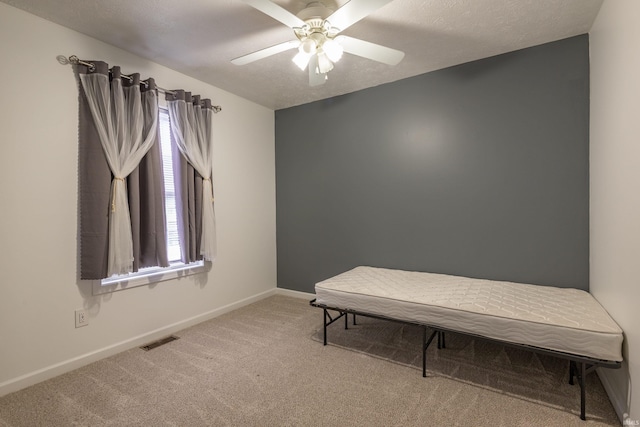 sitting room featuring visible vents, baseboards, ceiling fan, and carpet