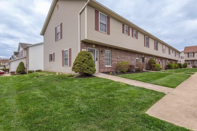 view of front of home with a front yard and brick siding
