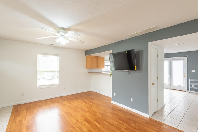 unfurnished living room featuring ceiling fan, baseboards, and visible vents
