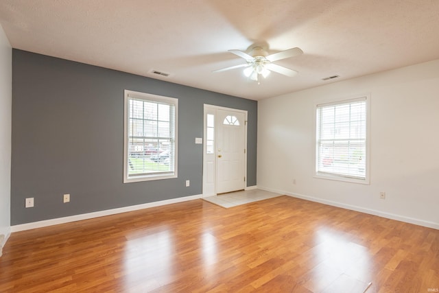 foyer featuring light wood finished floors, visible vents, and a ceiling fan