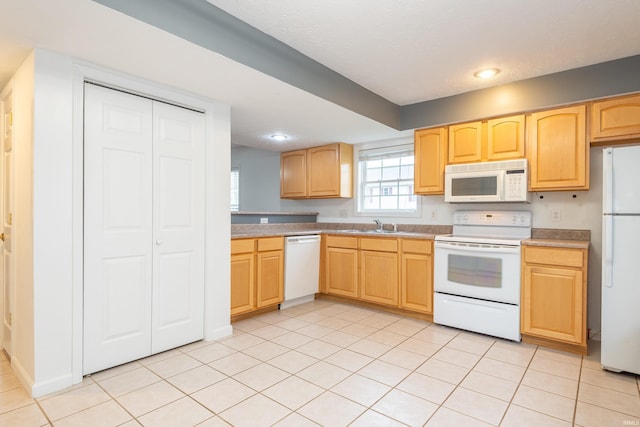 kitchen with light brown cabinets, recessed lighting, white appliances, light tile patterned flooring, and a sink