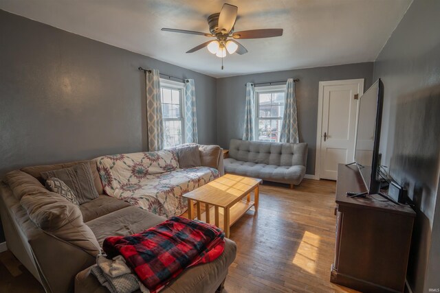 living room featuring wood-type flooring and a ceiling fan