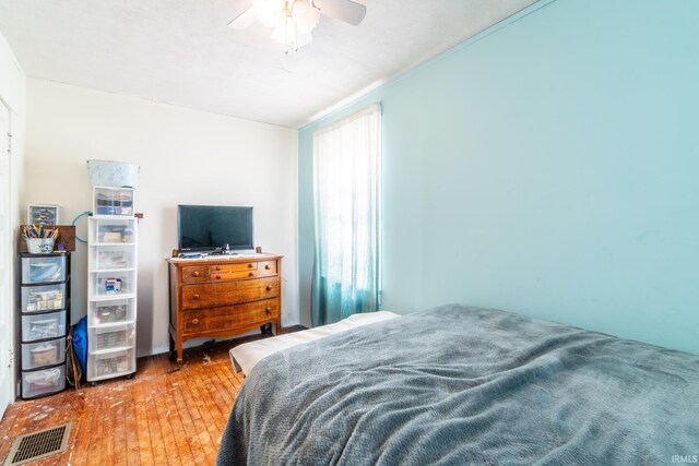 bedroom featuring ceiling fan, hardwood / wood-style floors, and visible vents