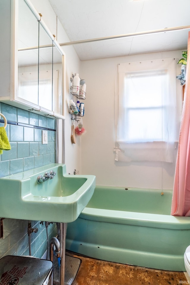 full bath featuring a sink, toilet, decorative backsplash, and shower / bathtub combination with curtain