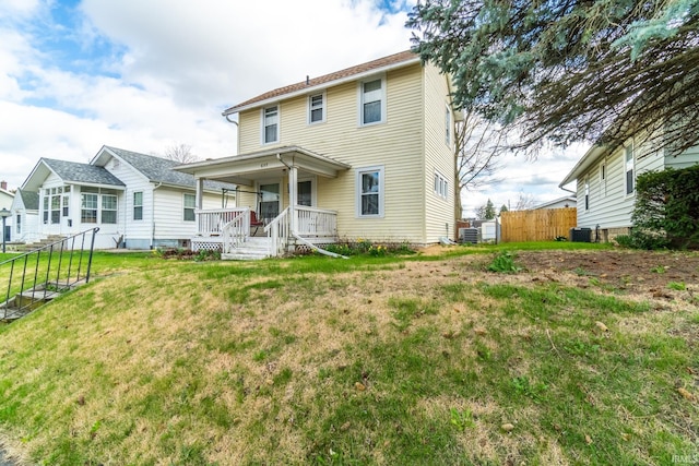 view of front of home featuring central AC, a porch, a front lawn, and fence