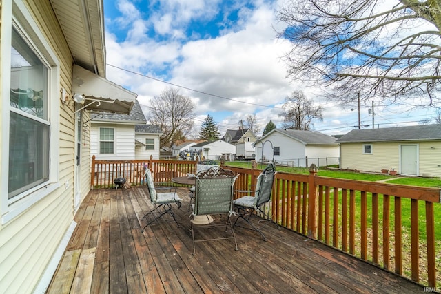 wooden terrace with a residential view, a lawn, outdoor dining area, and fence