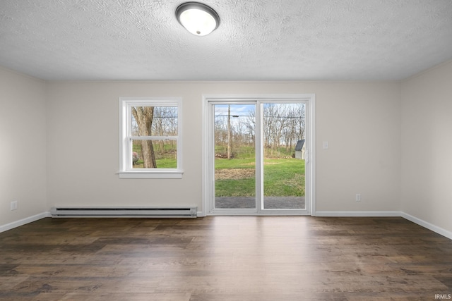 spare room with a textured ceiling, a baseboard radiator, baseboards, and wood finished floors