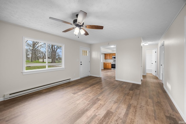 unfurnished living room with ceiling fan, dark wood-type flooring, a textured ceiling, a baseboard heating unit, and baseboards