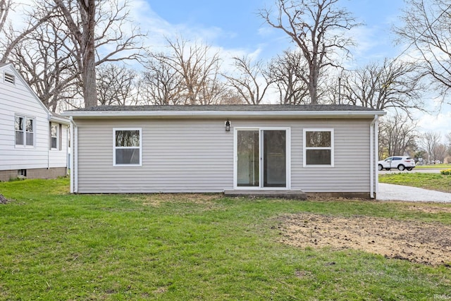back of property featuring a lawn