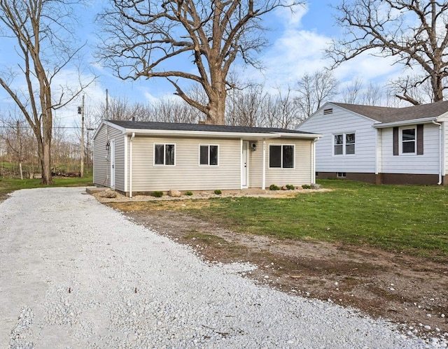 single story home featuring driveway and a front lawn