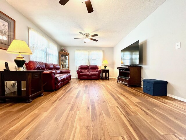 2119 Windwood Dr, Bedford, IN 47421 - living area with light wood finished floors, a textured ceiling, baseboards, and ceiling fan