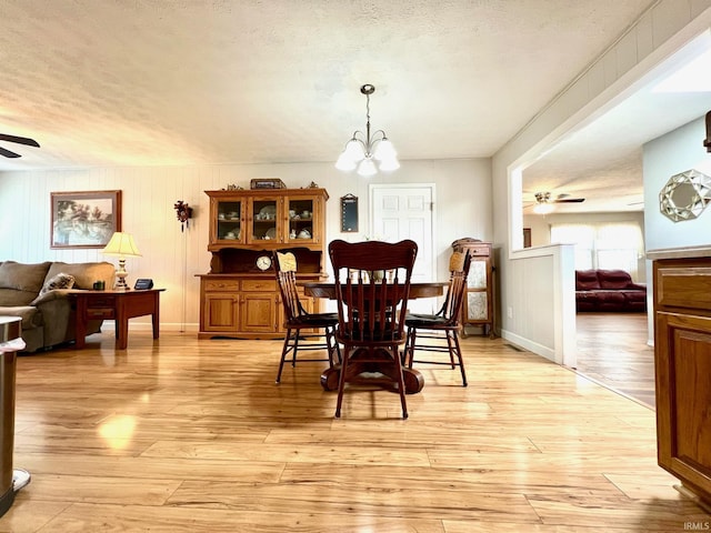 2119 Windwood Dr, Bedford, IN 47421 - dining area featuring a textured ceiling, ceiling fan with notable chandelier, and light wood finished floors