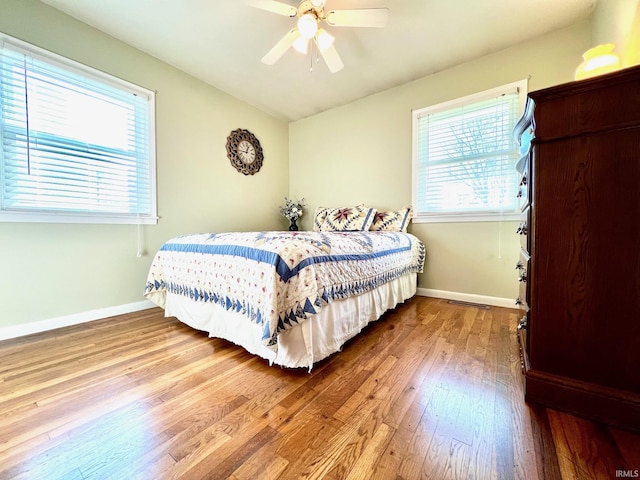 2119 Windwood Dr, Bedford, IN 47421 - bedroom with vaulted ceiling, multiple windows, hardwood / wood-style flooring, and baseboards