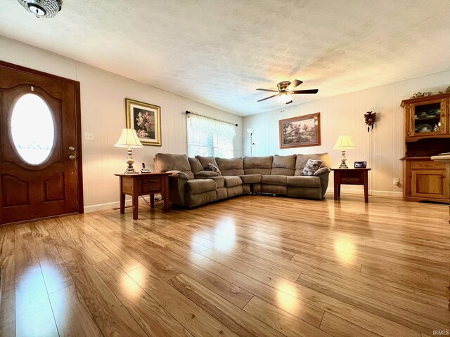 2119 Windwood Dr, Bedford, IN 47421 - living area featuring light wood-style flooring, a ceiling fan, baseboards, and a textured ceiling