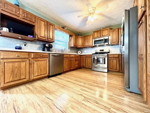 2119 Windwood Dr, Bedford, IN 47421 - kitchen with stainless steel appliances, light wood-style floors, light countertops, and brown cabinetry