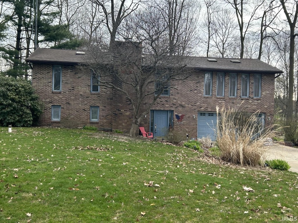 view of front of home with driveway, a garage, a front lawn, and brick siding