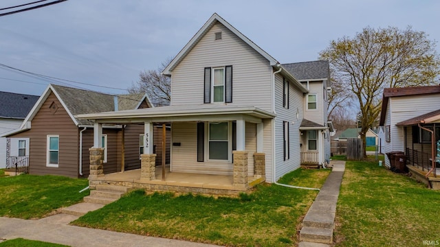 traditional home with a front yard, a porch, and fence