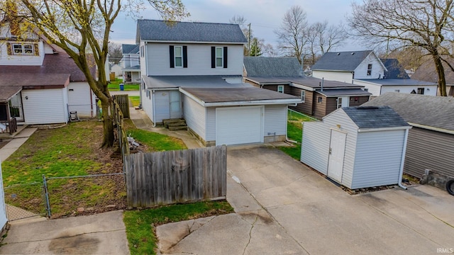 traditional-style house featuring a fenced front yard, roof with shingles, a residential view, and concrete driveway