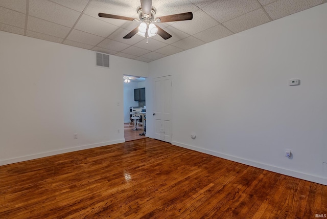 unfurnished room featuring visible vents, a paneled ceiling, and wood finished floors