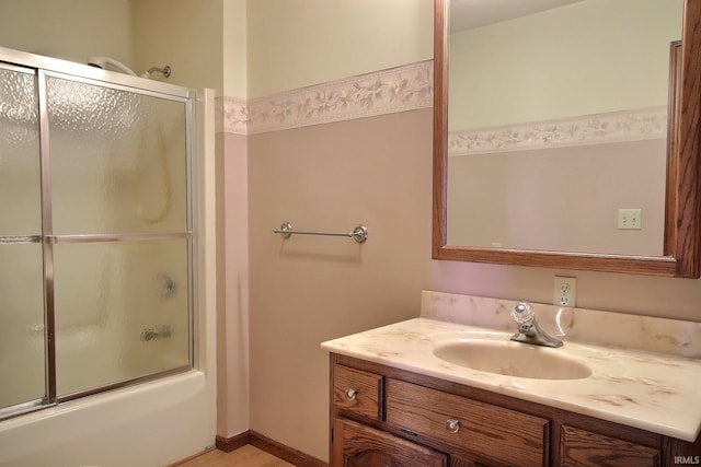 bathroom featuring enclosed tub / shower combo and vanity